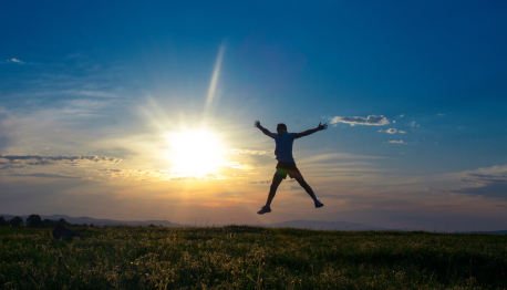 silhouette man jumping with open arms