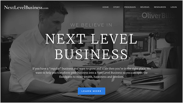 This is a screenshot of the Next Level Business website, a business run by Oli Billson. In the upper left is the website name in white text, NextLevelBusiness.com. In the upper right are navigation options in white text. The options are Home, Story, Programs, Reviews Resources, and Login. In the center of the page, in white text, a heading says, “We Believe in Next Level Business”. Below the heading is a short statement, “If you have a ‘regular’ business and want to grow and scale then you’re in the right place. We want to help you transform your business into a Next Level Business so you can open the floodgates to more wealth, happiness and freedom.” At the bottom of the page is a blue button with white text labeled “Learn More”. The web page background is a black and white photo of a white man with short hair sitting at a desk typing on an Apple laptop. He’s wearing a white button-down shirt and a watch on his left wrist. On the desk is a book stacked on top of a white binder. He’s sitting in an open office environment with other desks and computers.