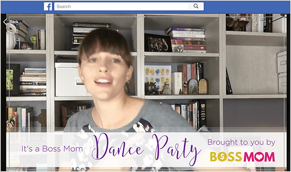 This is a screenshot of Dana Malstaff dancing in a Facebook video she created to celebrate a milestone in her Facebook group. Dana is a white woman pictured from the chest up in front of a white bookcase with books and white file boxes. Her hair is dark brown with bangs and the rest is pulled back in a ponytail. A banner at the bottom of the video says, “It’s a Boss Mom Dance Party brought to you by Boss Mom.”