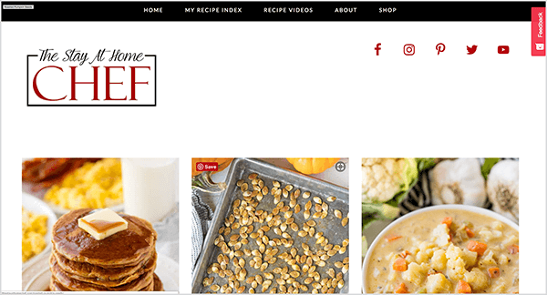 This is a screenshot of The Stay At Home Chef Website. At the top is a black bar with the following navigation options: Home, My Recipe Index, Recipe Videos, About, Shop. The Stay AT Home Chef title appears in the upper left in a script style font. Red social icons for Facebook, Instagram, Pinterest, Twitter, and YouTube appear in the upper right. Below the header are three photos from left to right: a stack of pancakes with a pat of butter on top, a pan of roasted pumpkin seeds, a bowl of cauliflower soup. Rachel Farnsworth started this site as a blog when she became a stay-at-home mom.