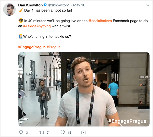 This is a screenshot of a tweet Dan Knowlton posted about the Engage Prague event. The text says “Day 1 has been a hoot so far! In 40 minutes, we’ll be going live on the @socialbakers Facebook page to do an #AskMeAnything with a twist. Who’s tuning in to heckle us? #EngagePrague #Prague”. Below this text is a video that shows highlights of the first day of the event. In the video still, Dan is speaking to the camera in an open conference space. Dan appears from the waist up. He’s a white man with short brown hair. He’s wearing a gray t-shirt and a black lanyard.