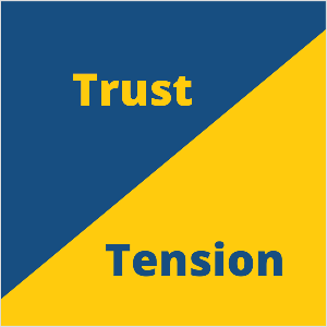This is an square illustration of Seth Godin’s marketing concept of trust and tension. The square is a blue triangle in the upper left and a yellow triangle in the lower right. In the blue triangle, yellow text says Trust. In the yellow triangle, blue text says Tension.