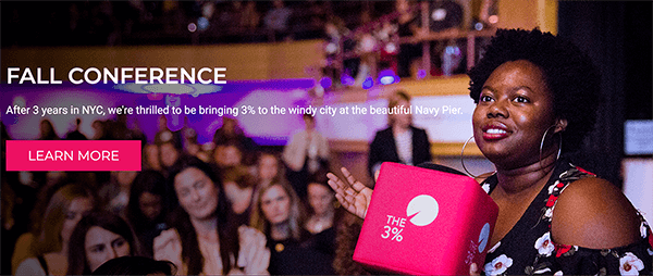 This is a screenshot from the website for The 3% Conference. In an photo, a black woman holds a bright pink cube with the conference logo printed on it. Behind her is a crowd of women at the conference. The white text over the image says “After 3 years in NYC, we’re thrilled to be bringing 3% to the windy city at the beautiful Navy Pier.” A bright pink button says “Learn More”. Melissa Cassera says this conference is an example of a business with a quest story.